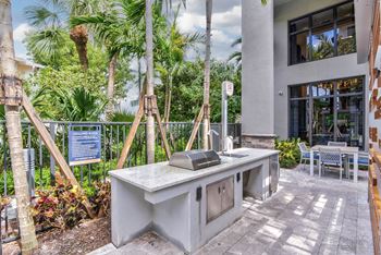 A concrete desk with a chair and a signboard in the background at Mayla Pompano, Pompano Beach, Florida